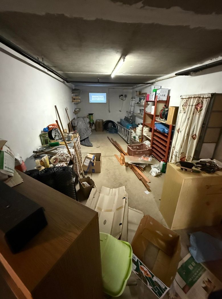 Keller vorher, voll mit Regalen, Kartons und Gerümpel